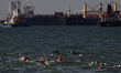 Participants competing in the swim leg of a local triathlon competition are pictured again...