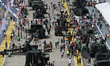 People view and take photos of military vehicles and tanks on display during the Army Open...