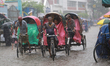 Rickshaw pullers make their way during the rainfall in Dhaka, Bangladesh on May 30, 2022....