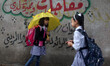 A Palestinian schoolgirl hold an umbrella as they go to school on a rainy day in  Gaza Cit...