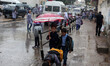 Palestinian schoolboys hold an umbrella as they go to school on a rainy day in  Gaza City...