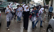 Palestinian schoolgirls  go to school on a rainy day in  Gaza City October 7, 2015.  