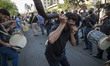 Iranian men play traditional musical instruments while taking part a mourning ceremony to...
