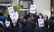 Iranian women hold-up placards with Persian scripts read, Condolences my Iran, while takin...