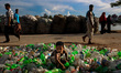 Oct 07, 2015 - Dhaka, Bangladesh - Boy sits on plastic bottles at a road side bottle recyc...