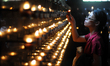 QUEZON CITY, Philippines - A woman lights a candle after taking part at the Stations of th...