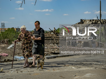 An old woman with her son leave their destroyed home after a russian airstrike over Druzhkivka city. (