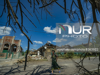 A woman walks surrounded of the destruction after a russian airstrike over a civilian area of Druzhkivka city (