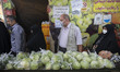 Iranian people line-up while shopping at a fruit and vegetable shop at the Shapour Bazaar...