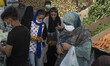 An Iranian woman and her daughter carrying fruits while shopping at a fruit and vegetable...