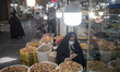 A veiled Iranian woman stands at a nuts shop while shopping in the Shapour Bazaar (Market)...