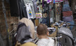 An Iranian reseller looks on while sitting at his small dress shop in the Shapour Bazaar (...