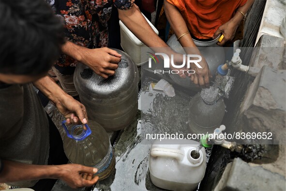 People gather around a water pipeline to collect drinking water as the supplied water in their houses is not eligible to drink in the Lalbag...