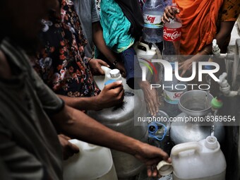People gather around a water pipeline to collect drinking water as the supplied water in their houses is not eligible to drink in the Lalbag...