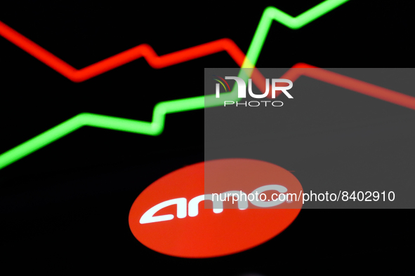 AMC logo displayed on a phone screen is seen with an illustrative stock chart displayed on a screen in the background this illustration phot...
