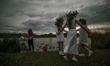 Three young women in a flower wreaths dancing by the Wislok River during the Kupala Night...