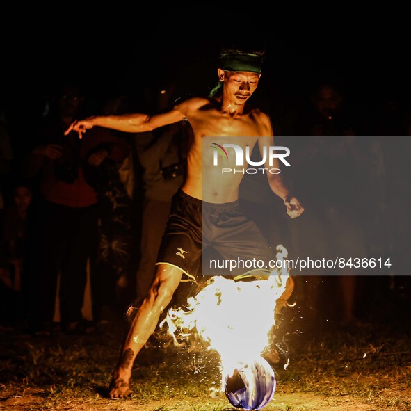 Villagers playing fire football, known locally as "sepak bola api", a fireball made from a coconut from a palm tree soaked during an annual...