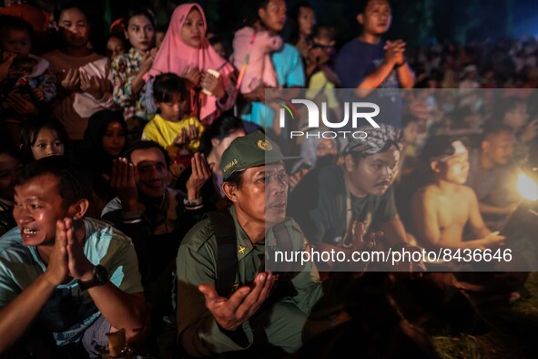Villagers watch the fire battle, known locally as "sepak bola api", a fireball made from a coconut from a palm tree soaked during an annual...