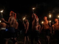 Villagers carry torches as they participate in playing fire football, known locally as "sepak bola api", a fireball made from a coconut from...