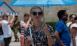 A woman uses an ombrella for protection during a heatwave in Athens, Greece, on June 23, 2...