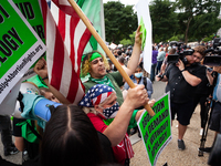 A pro-choice protester is framed by another's American flag prior to the announcement of the Supreme Court's opinion on Dobbs v. JWHO.  The...