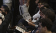 An Iranian man holds his bidding sign while sitting in an auction hall during the 7th Art...