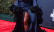American singer Lizzo wearing a custom Gucci feathered gown arrives at the BET Awards 2022...
