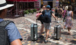 A tourist is walking holding two suitcases at Monastiraki square in Athens, Greece on July...