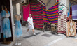A man is walking in front of a store with clothes near Monastiraki square in Athens, Greec...