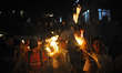 A Nepalese devotee carries a traditional torch of straw during the last day of the Rato Ma...