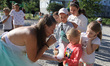 LUBNY, UKRAINE - JULY 14, 2022 - A woman blows foam onto the palms of a girl during a fest...