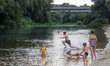 LUBNY, UKRAINE - JULY 15, 2022 - Children bathe in the Sula River, Lubny, Poltava Region,...
