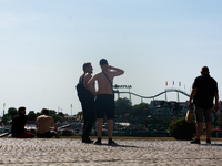 Two young men stands  along the Rhine river in the mid of day in Duesseldorf, Germany on July 18, 2022 as a heat wave reaches to Germany (