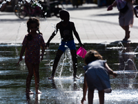 Kids play with the water of a fountain in city center of  Duesseldorf, Germany on July 18, 2022 as a heat wave reaches to Germany (