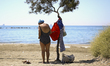 An elderly woman leaves her belongings on a tree before going for a swim on the promenade...
