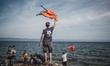 Volunteers waves lifejackets to direct boats to the safe areas to land on the shores of Le...