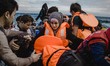 A Syrian women is helped by other migrants onto the shore on the Greek island of Lesbos, o...