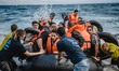Volunteers help migrants embark from the dinghy they have arrived on, in Lesbos, on Septem...