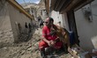 A member of the Iranian Red Crescent Society (IRCC) and his rescue dog sit on a corner of...
