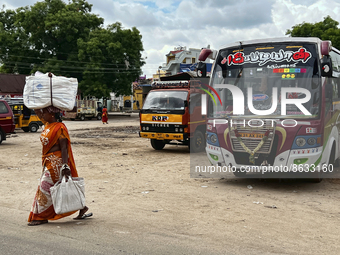 Woman carries a heavy bundle atop her head near the bus stand in Nilakkottai (Nilakottai), Tamil Nadu, India, on May 18, 2022.  (