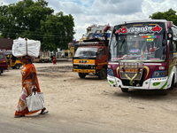 Woman carries a heavy bundle atop her head near the bus stand in Nilakkottai (Nilakottai), Tamil Nadu, India, on May 18, 2022.  (