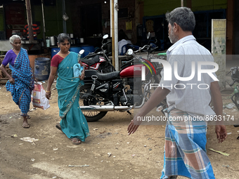 People walk past shops in the town of Nilakkottai (Nilakottai), Tamil Nadu, India, on May 18, 2022. (