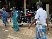 People walk past shops in the town of Nilakkottai (Nilakottai), Tamil Nadu, India, on May 18, 2022. (