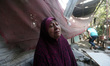 A Palestinians woman reacts as she sits amidst the rubble of her home, destroyed during ov...