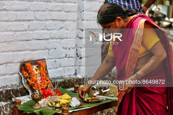 Woman lights a lamp at a small shrine dedicated to Goddess Attukal Devi seen along the roadside during the final day of the 10 day-long Attu...