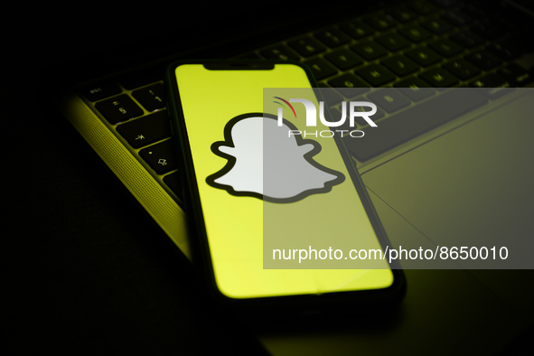 Snapchat logo displayed on a phone screen and a laptop keyboard are seen in this illustration photo taken in Krakow, Poland on August 10, 20...