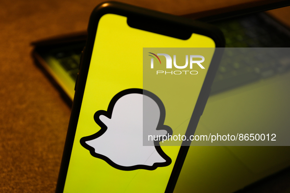 Snapchat logo displayed on a phone screen is seen with a laptop in the background in this illustration photo taken in Krakow, Poland on Augu...