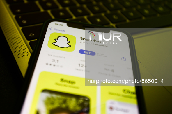 Snapchat on the App Store displayed on a phone screen and a laptop keyboard are seen in this illustration photo taken in Krakow, Poland on A...