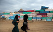  Palestinian women walk during a windy day  next a big stone wall on Oct. 25, 2015. that w...