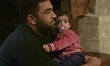 A young refugee with his daughter awaiting to enter to the Aspa Boomerang Restaurant, as t...